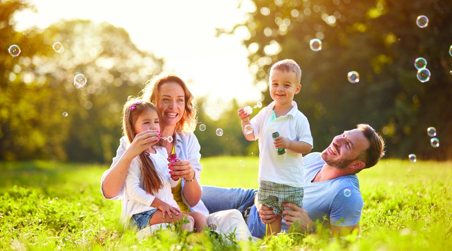 Family with children blow soap bubbles outdoor